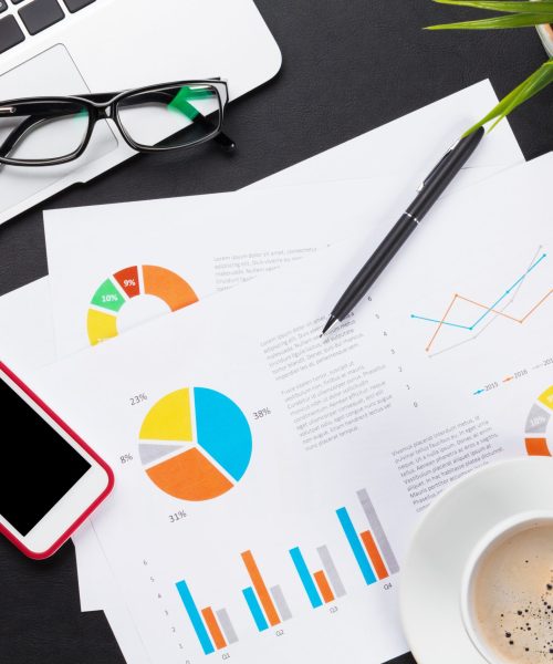 Office leather desk table with laptop, coffee cup, smartphone and reports. Top view with copy space